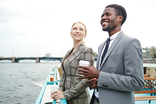 Happy man and woman in formalwear enjoying their business trip by steamship
