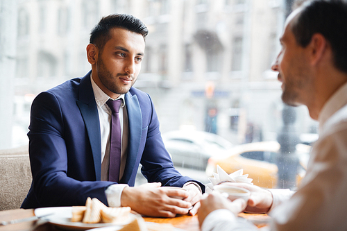 Young employee listening to colleague ideas at lunch-break