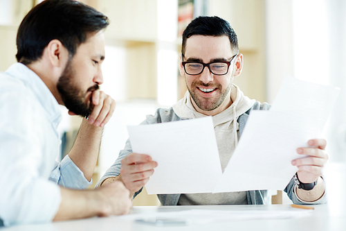 Young economists discussing documents at work