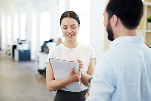 Secretary making notes while talking to employer