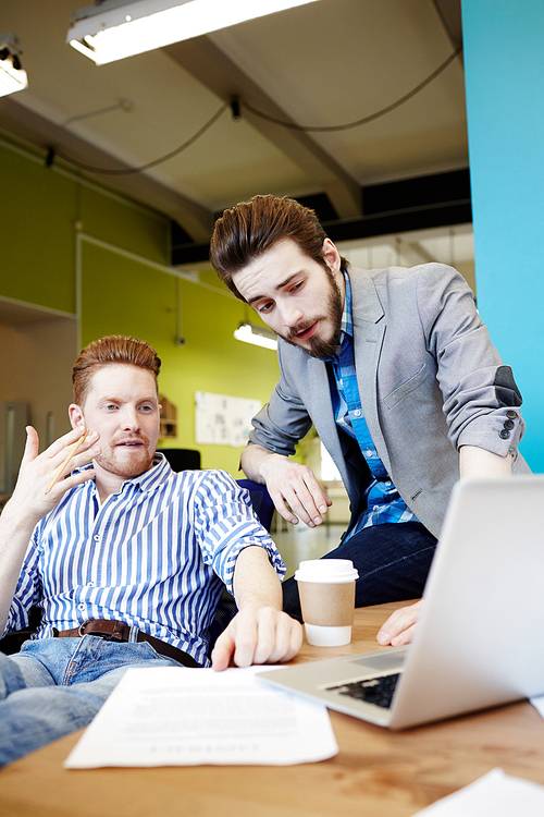 Creative businessmen brainstorming in front of laptop