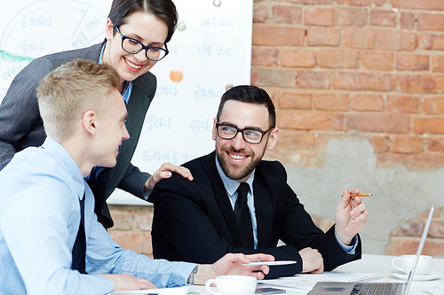 Happy co-workers having discussion of online information