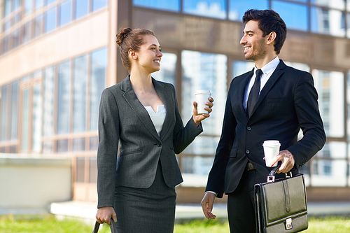 Two young entrepreneurs having talk while walking in the city