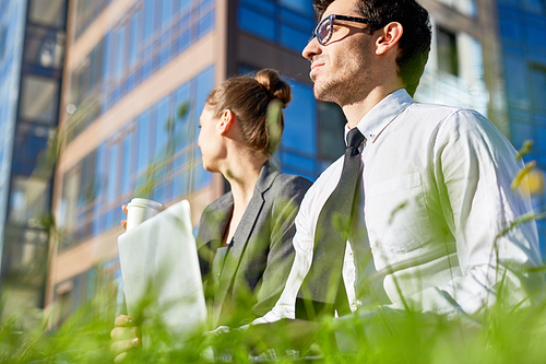 Businessman with laptop having minute of rest on sunny day