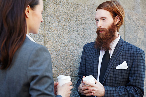 Elegant man with beard talking to colleague at coffee-break