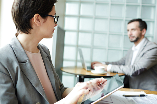 Modern female with touchpad networking and interacting with colleague