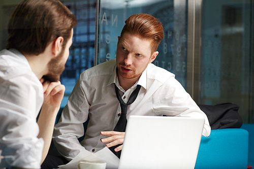 Serious co-workers discussing business information