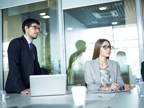 Serious colleagues listening to explanation in office