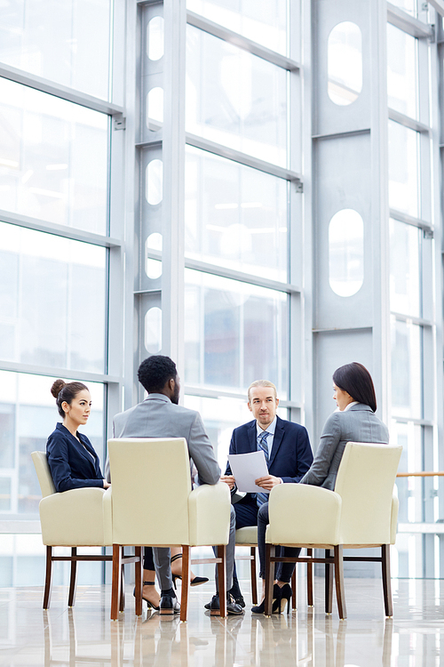 Business people gathered at briefing to discuss financial documents