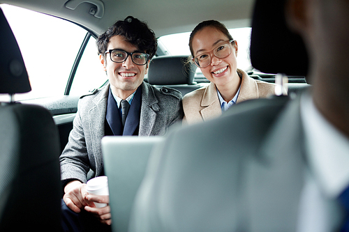 Two young managers  from backseat of car