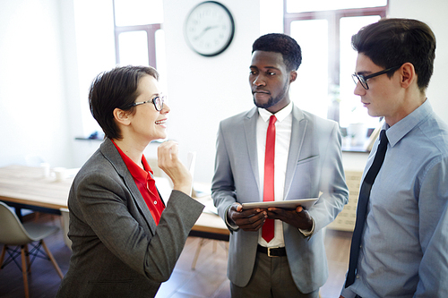 Confident businesswoman describing new subordinate to her colleagues