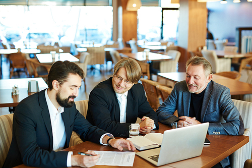 Young businessman going to sign contract with two employers near by