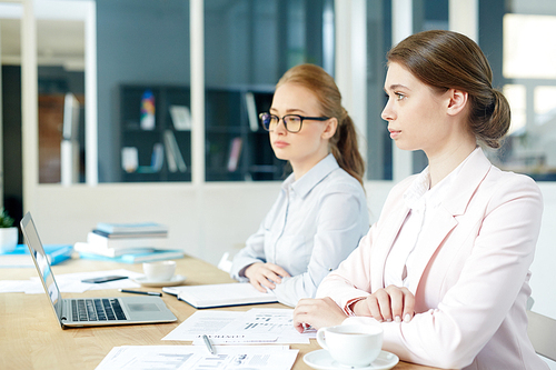 Two girls sitting by desk at briefing