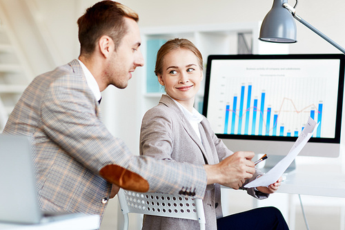 Financiers consulting about information in document during meeting