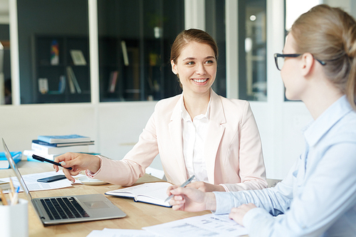 Start-up meeting of two confident businesswomen - discussing project or analyzing data