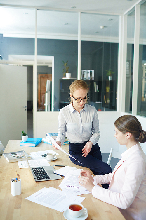 Two female employers discussing resume of applicants before or after interview