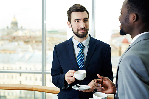 Elegant businessman listening to his colleague at break