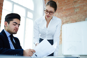 Young co-workers consulting about signing contract with new partner in office after negotiation