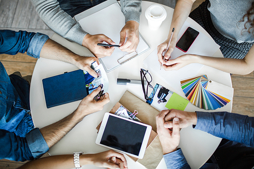 Top view of hands of designers during planning work or brainstorming