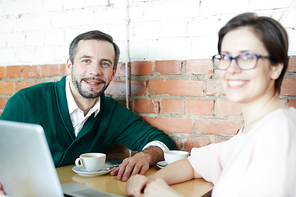 Young successful co-workers having coffee-break in cafe