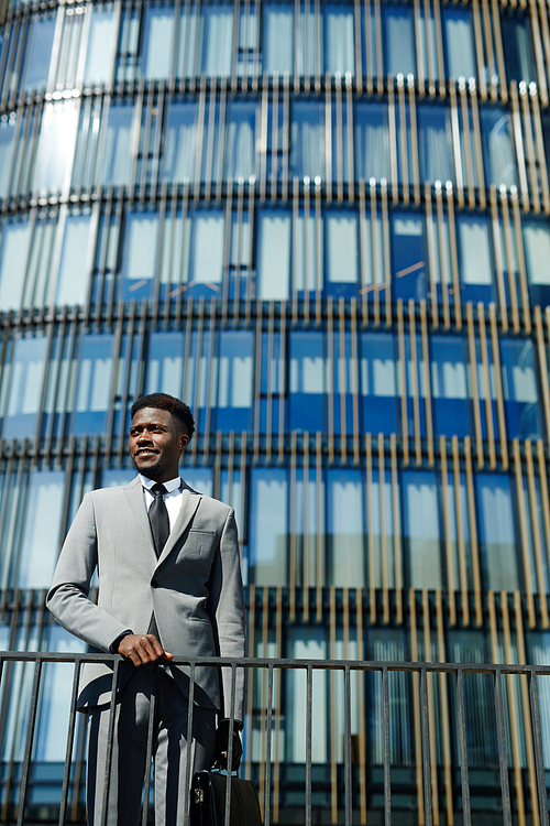 Successful modern trader in suit on background of skyscraper