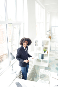 Well-dressed modern businessman working with papers in office