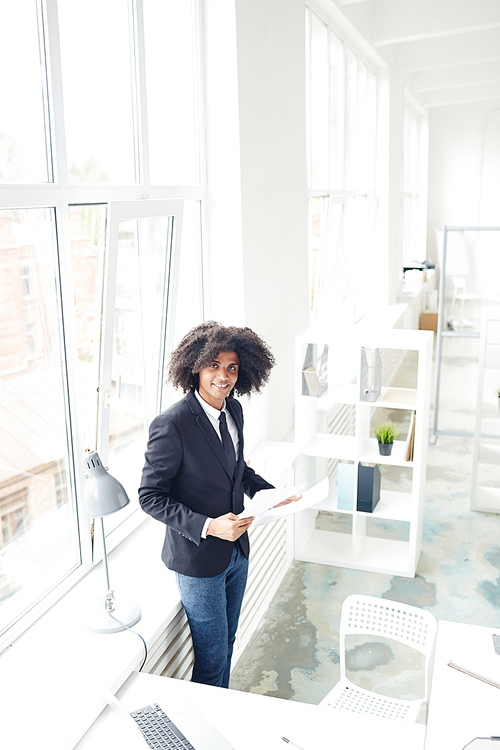 Well-dressed modern businessman working with papers in office