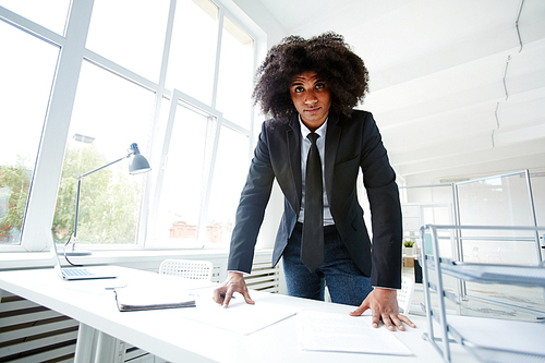 Elegant businessman leaning over his workplace and 