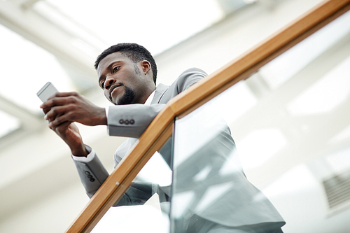 Serious businessman reading sms in smartphone