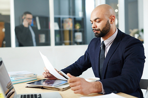 Serious economist concentrating on reading document