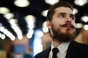 Posh man with beard and moustache on background of night lights