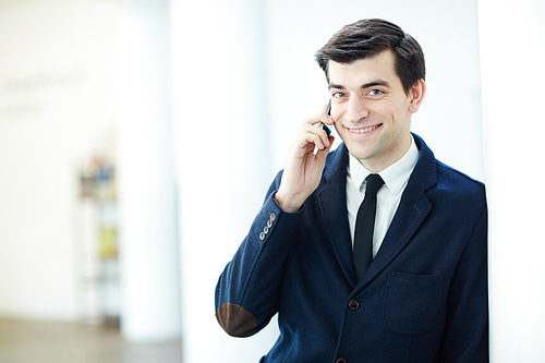 Happy broker speaking on cellphone with client