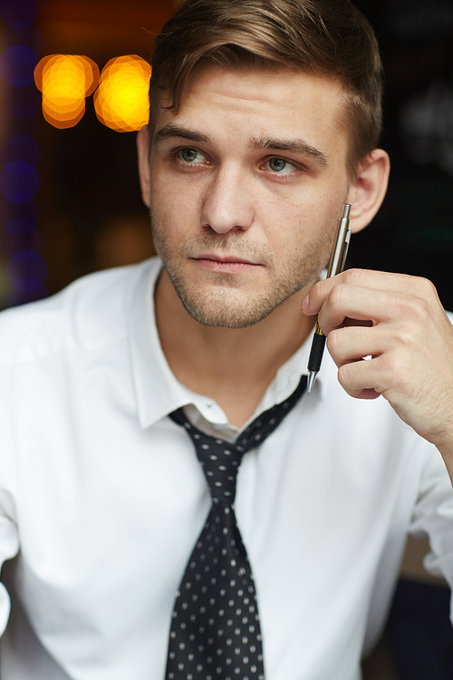 Portrait of handsome young businessman looking away wearing shirt and tie while working  in office