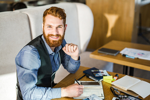 Happy business leader writing working plan in notebook