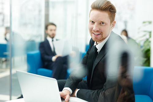 Modern business leader with laptop working in office