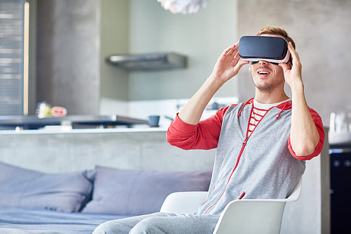Contemporary guy with vr headset enjoying new format video at leisure