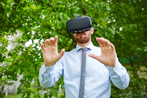 Portrait of man wearing VR gear experiencing nature walking in forest in real world