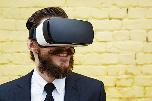 Cheerful businessman with vr goggles watching 3d video at leisure