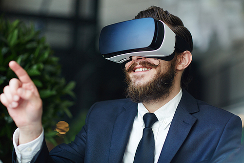 Happy man in suit and vr headset gaming in imaginary world