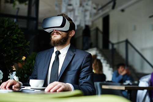Businessman having virtual experience in cafe