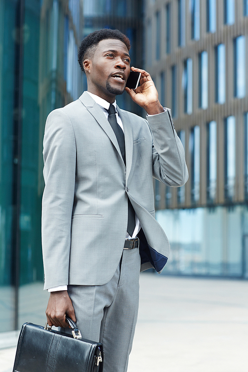 Businessman in suit calling in urban environment