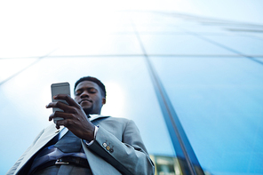 Smartphone in hand of young man in grey suit