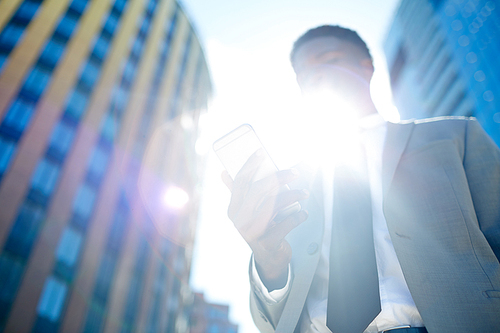 Elegant man with smartphone and sun flare