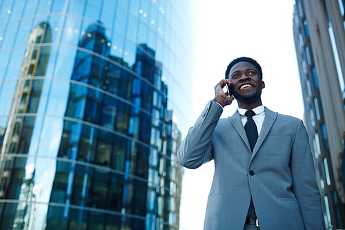 Happy specialist talking by mobile phone outdoors