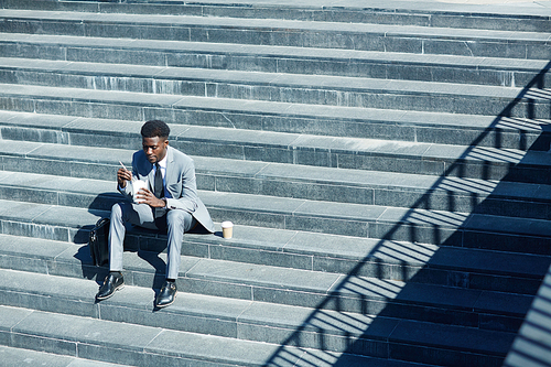 Hungry businessman eating with chopsticks on sunny day