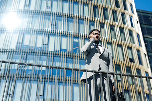Businessman communicating on cellphone in urban environment