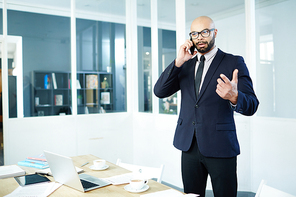 Well-dressed broker consilting client on the phone