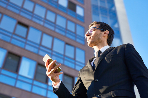 Man with mobile phone on background of modern office-center