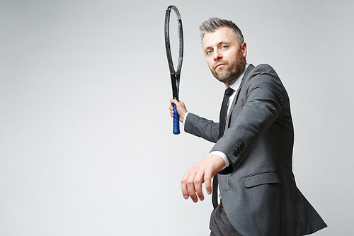 Waist up portrait of handsome middle aged man in business suit  while countering tennis ball, copy space to the left
