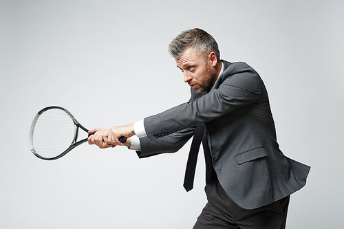 Waist up portrait of confident middle aged businessman countering tennis ball against grey background